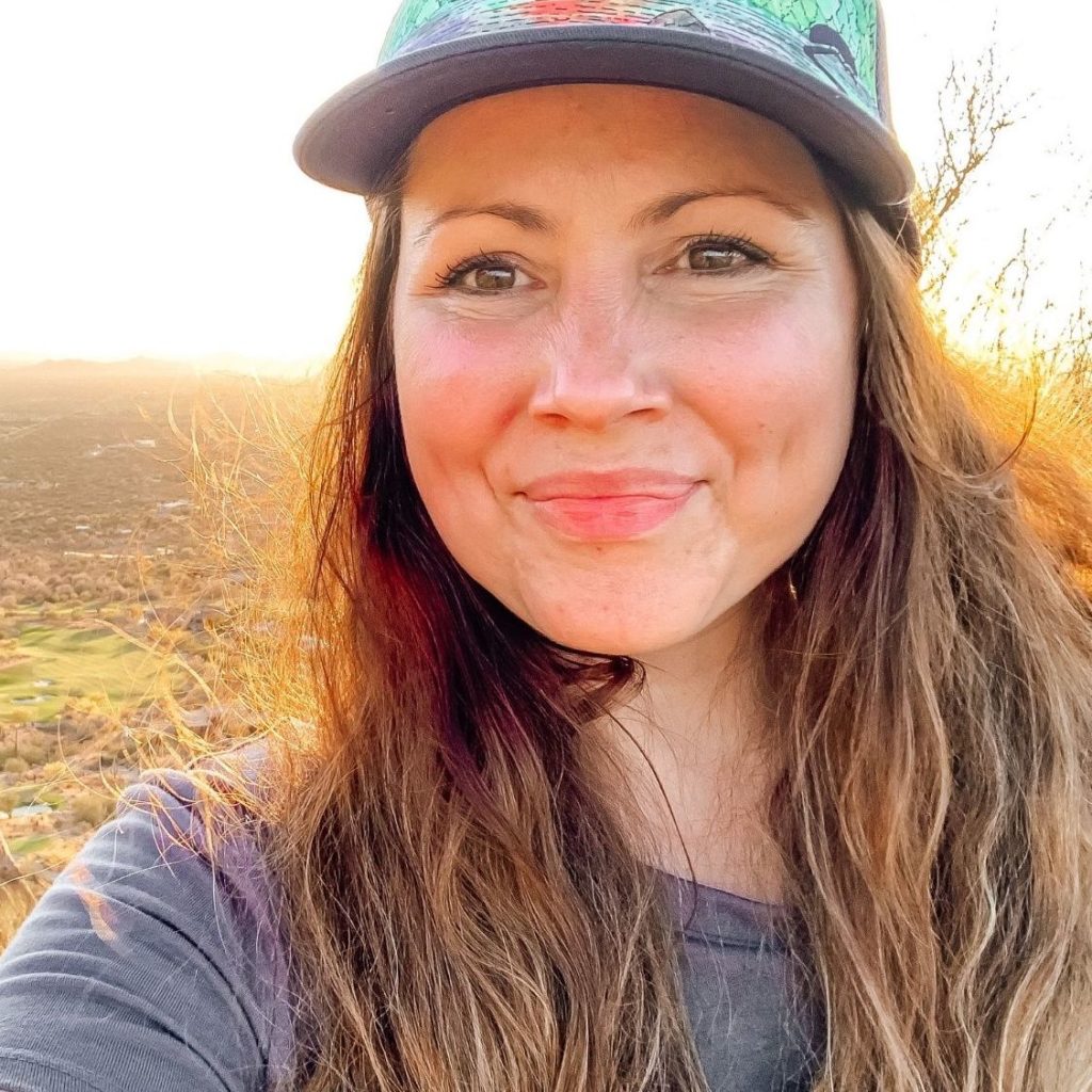 Heather The Legal Website Warrior® hiking with a sunset behind her.